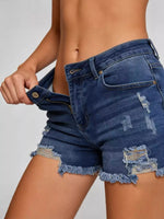 Person wearing blue denim shorts on a plain background