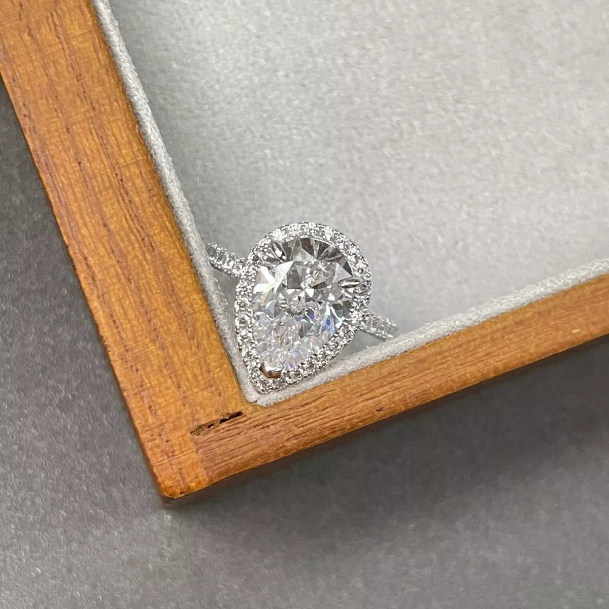 Diamond ring in a wooden box on a gray surface
