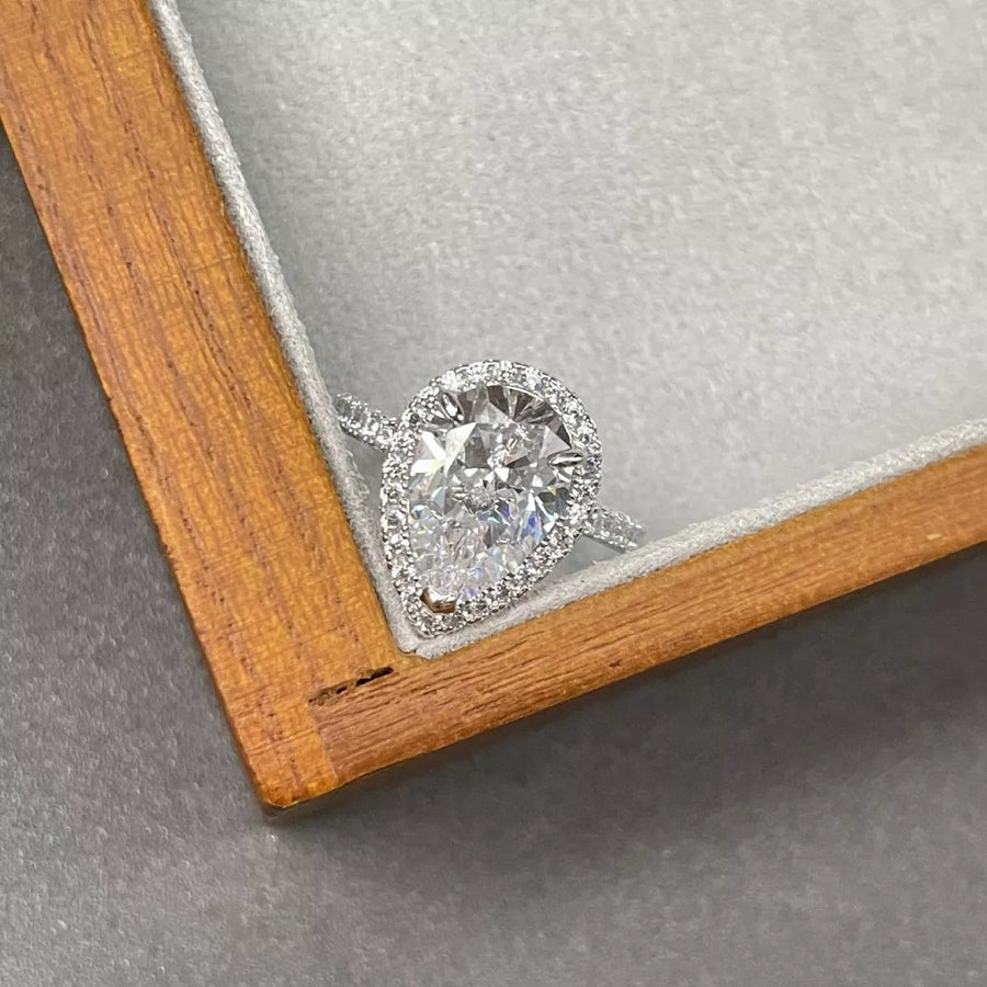Diamond ring in a wooden box on a gray surface