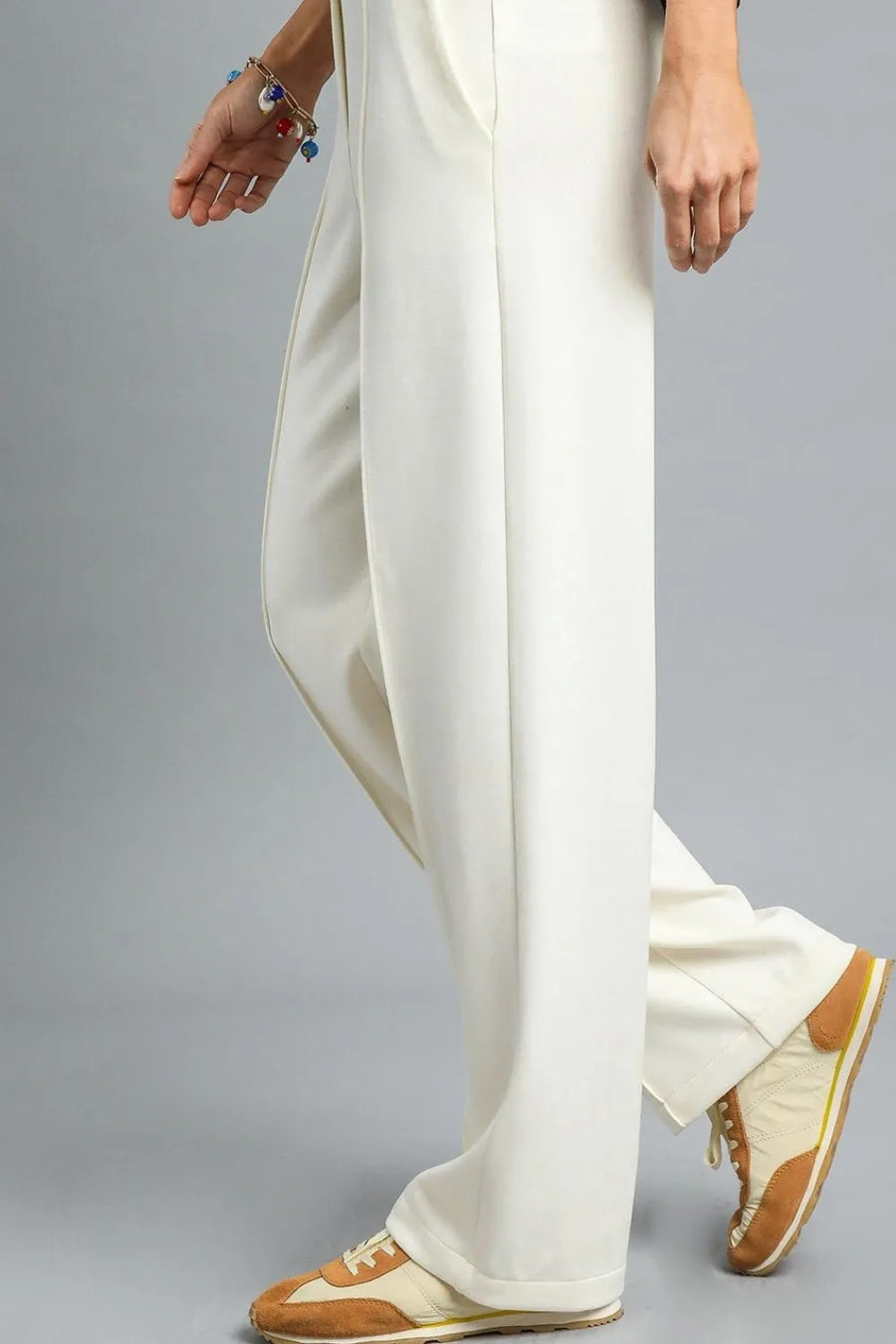 White pants worn by a person on a gray background