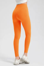 Orange leggings worn by a person on a white background