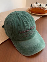 Green cap with 'National Bank' embroidery on a wooden surface with a cake in the background