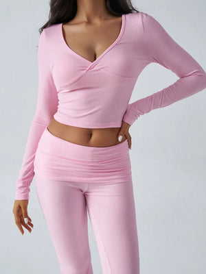 Person wearing a pink long-sleeve top and pants on a gray background