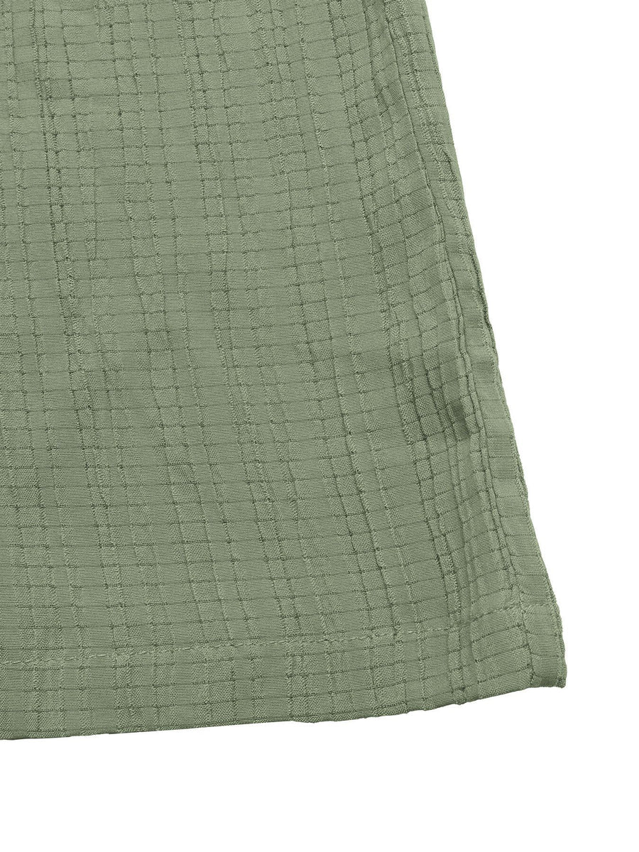 Close-up of a textured green fabric corner on a white background