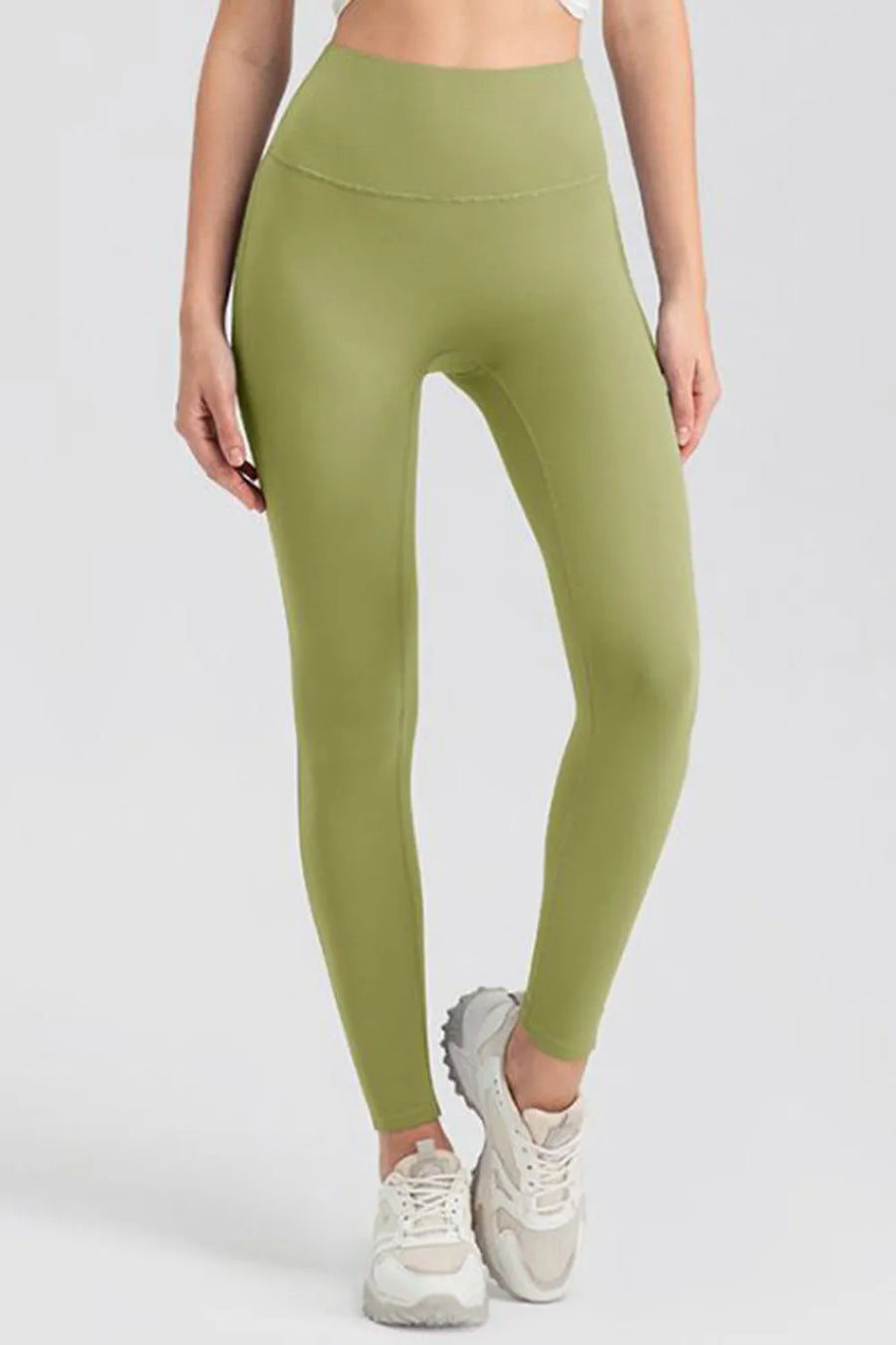 Person wearing green leggings on a white background