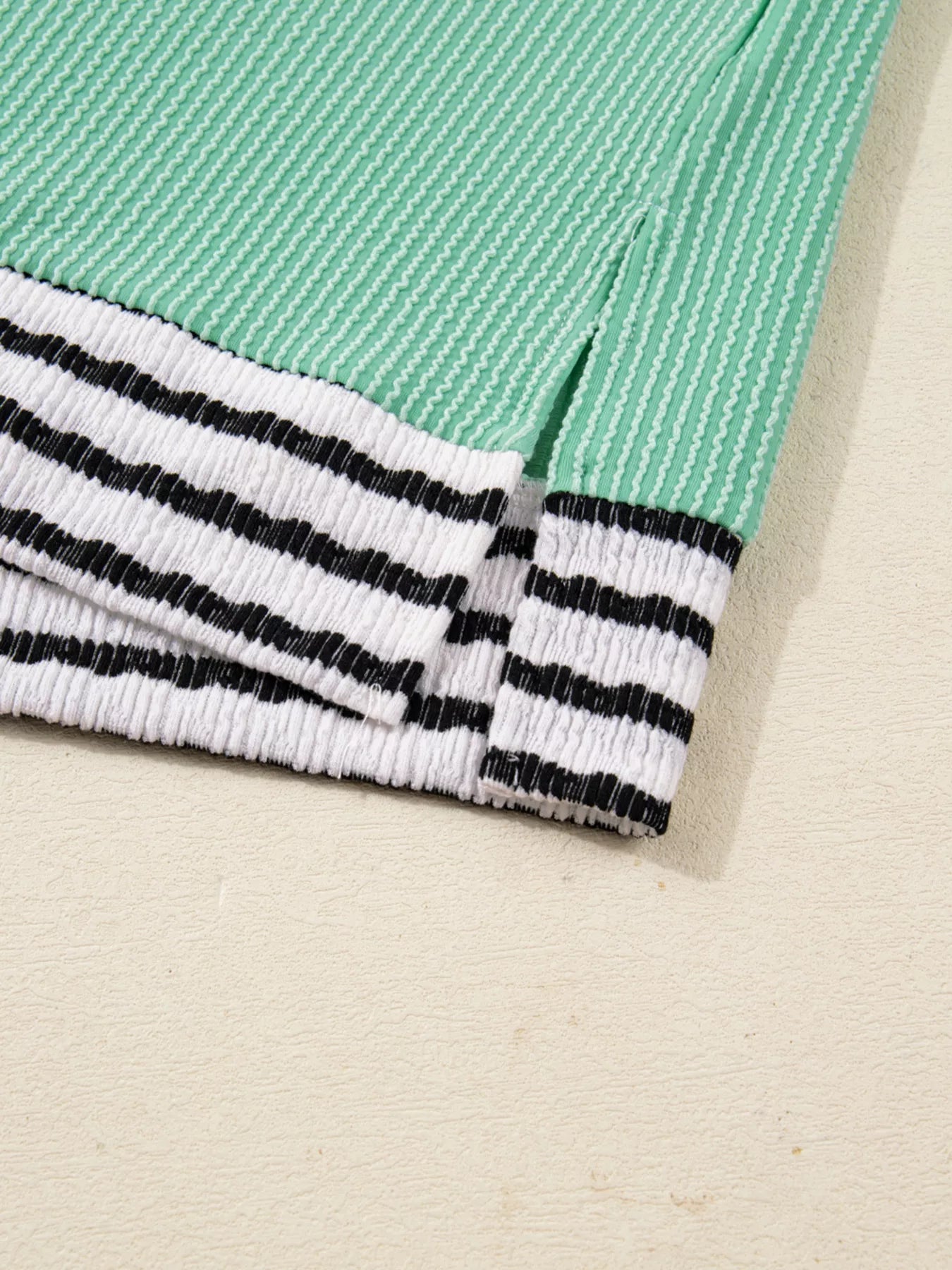 Close-up of a green and beige fabric with black and white striped pattern