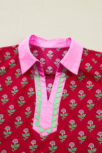 Red shirt with pink collar and green accents on a beige background