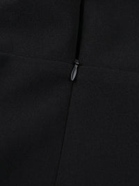 Close-up of a black coat with a zipper detail on a dark background