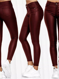 Maroon leather pants worn by a person on a white background