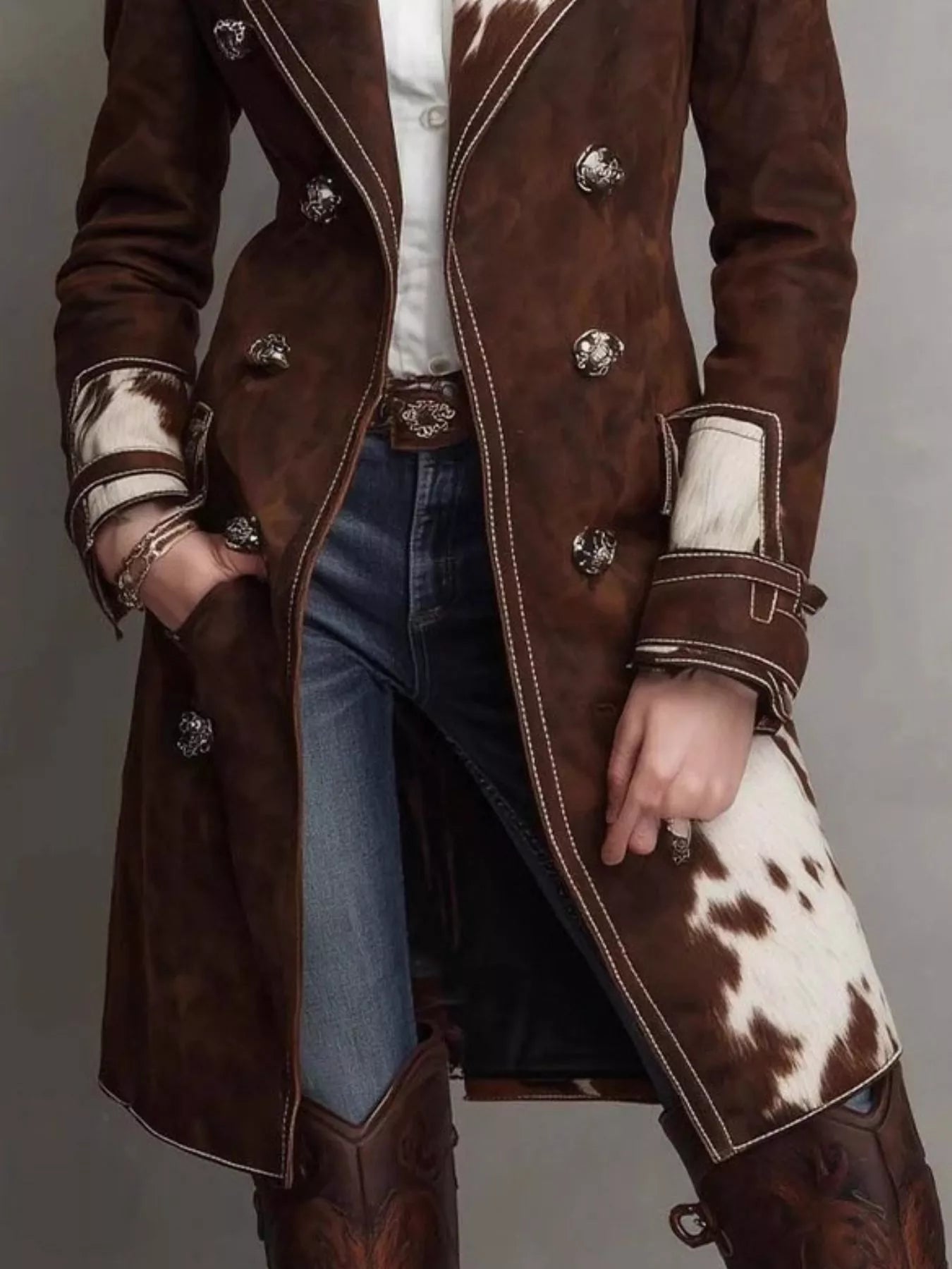 Brown leather coat with cowhide trim worn by a person on a gray background