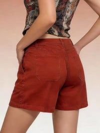 Person wearing red shorts with a neutral background