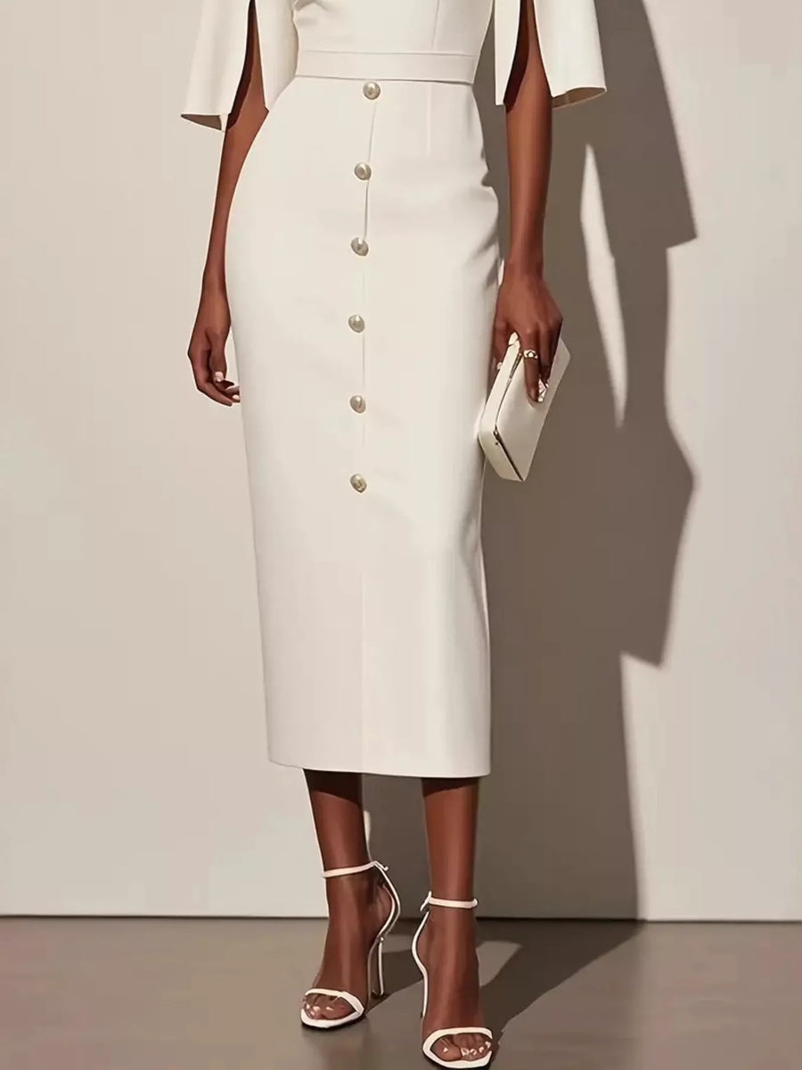 Woman wearing a white dress with buttons against a plain background