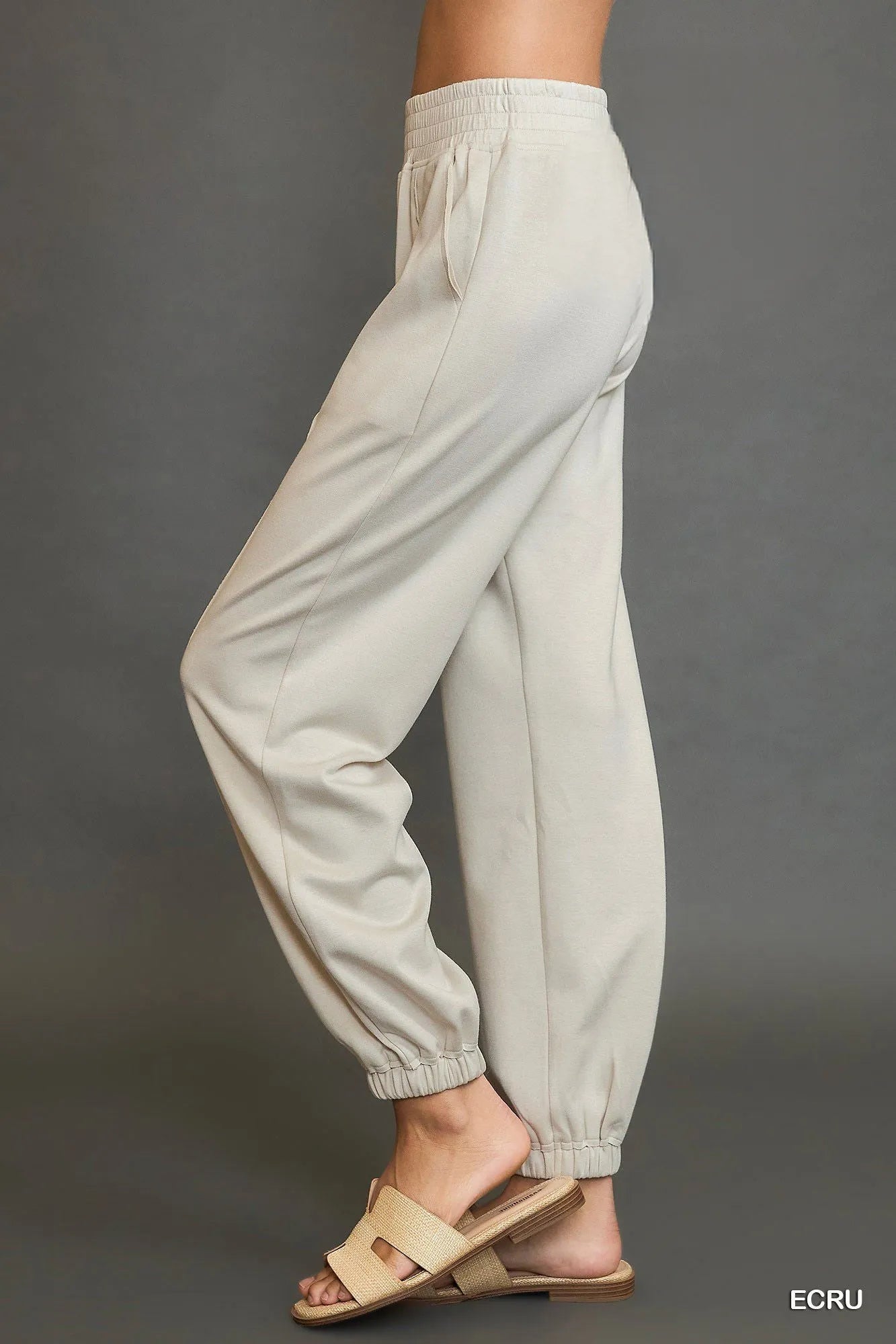 Light gray pants worn by a person on a dark gray background