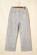Leopard print pants on a hanger against a beige background