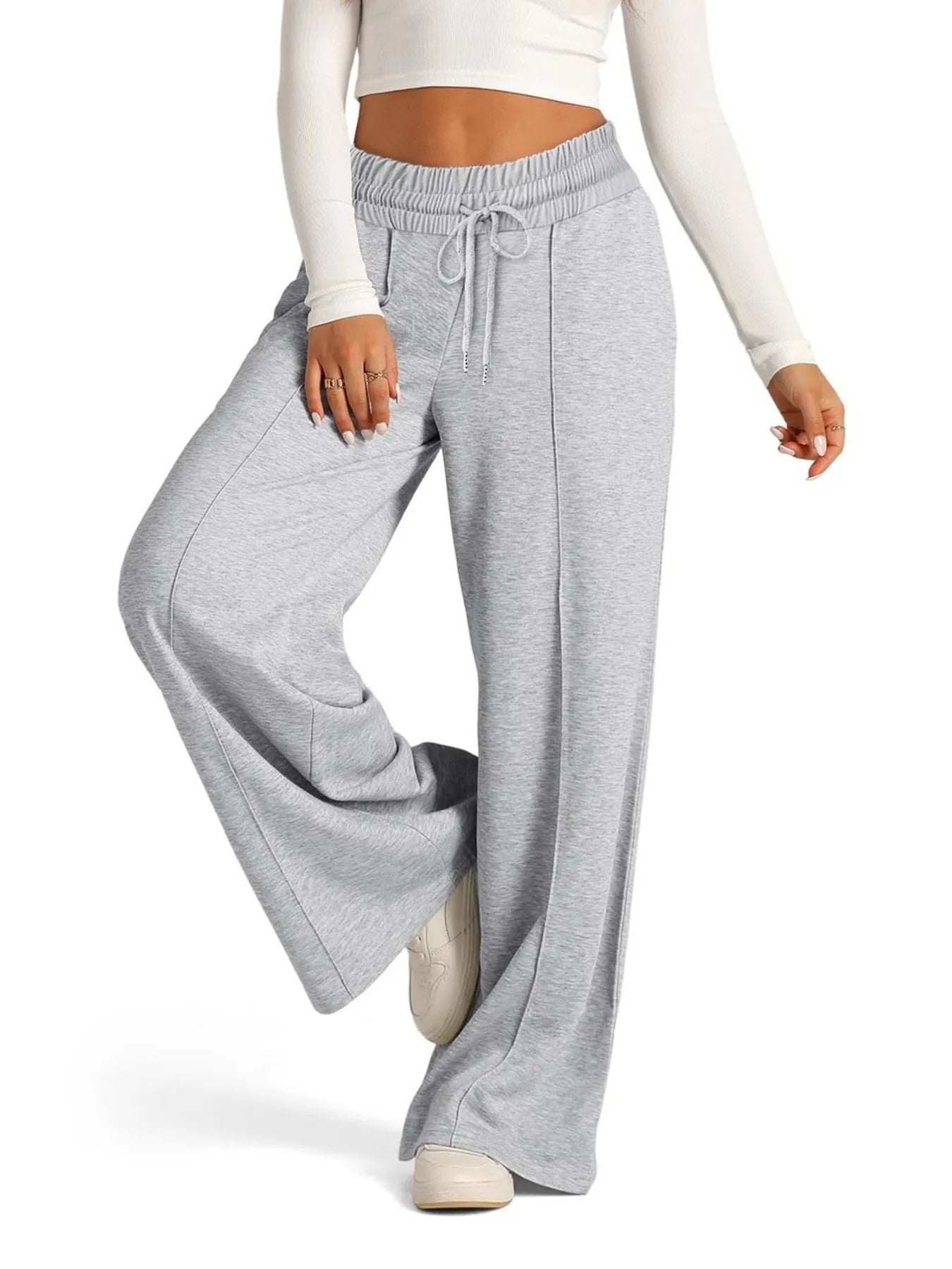 Gray sweatpants worn by a person on a white background