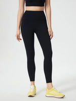 Person wearing black leggings and yellow sneakers on a white background