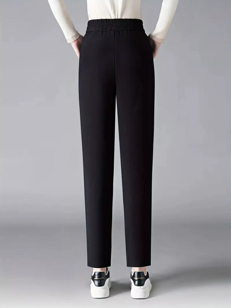 Black pants worn by a person on a gray background