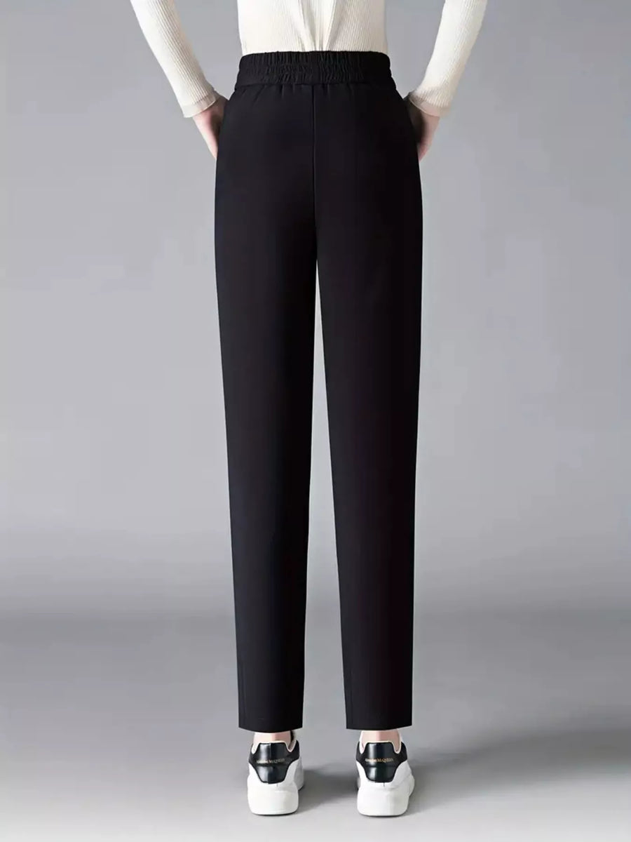 Black pants worn by a person on a gray background