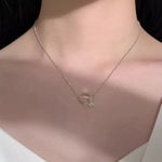 Necklace with a pendant on a person's neck against a neutral background