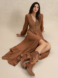 Woman wearing a long brown dress and matching boots on a beige background