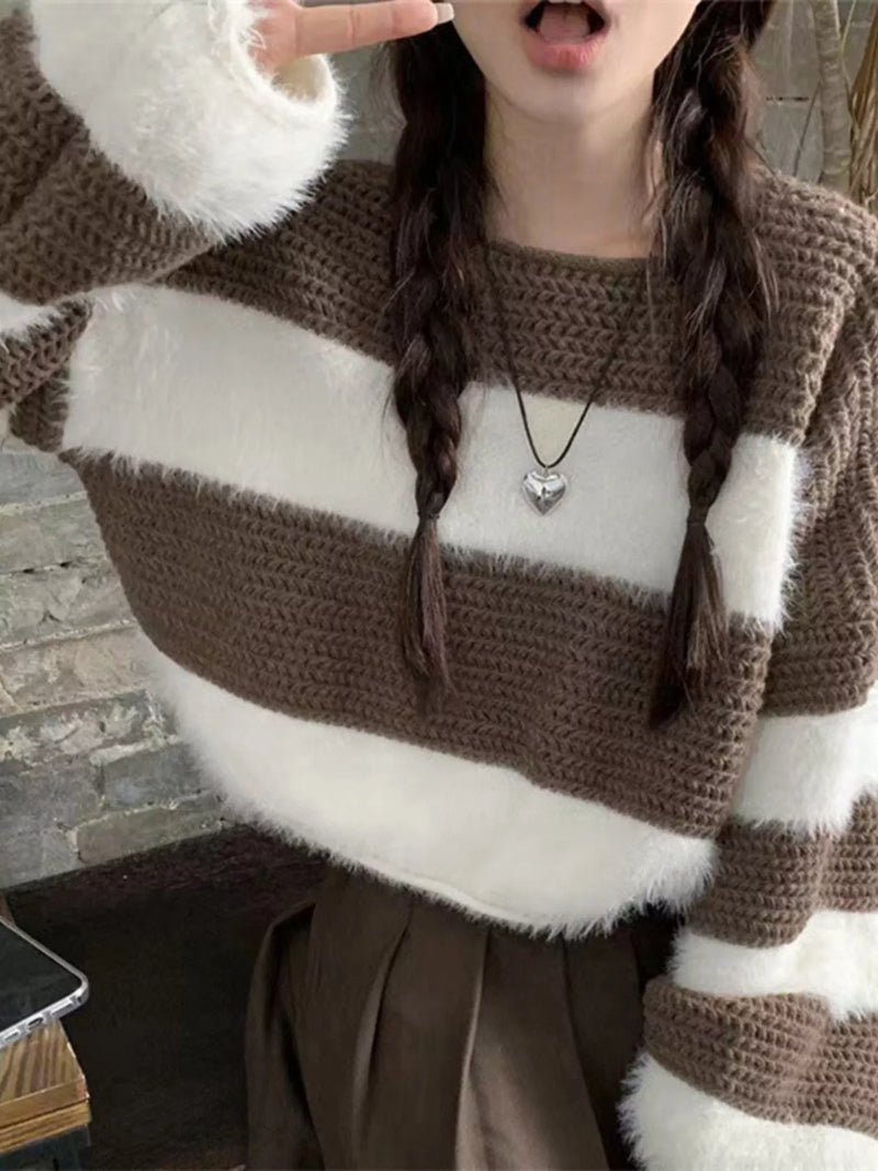 Person wearing a brown and white striped sweater with a heart-shaped pendant.