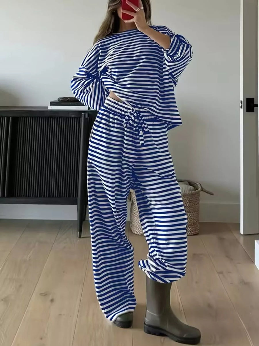 Person wearing a blue and white striped outfit with gray boots indoors.