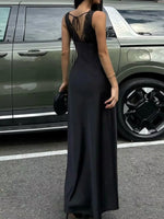 Person wearing a black dress standing next to a green SUV.