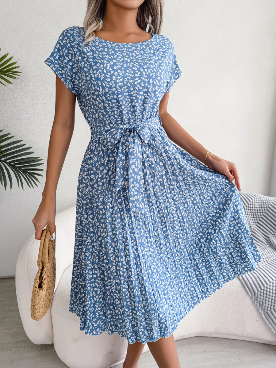 Woman wearing a blue floral dress in an indoor setting