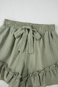 Green shorts with a tie waist on a white background