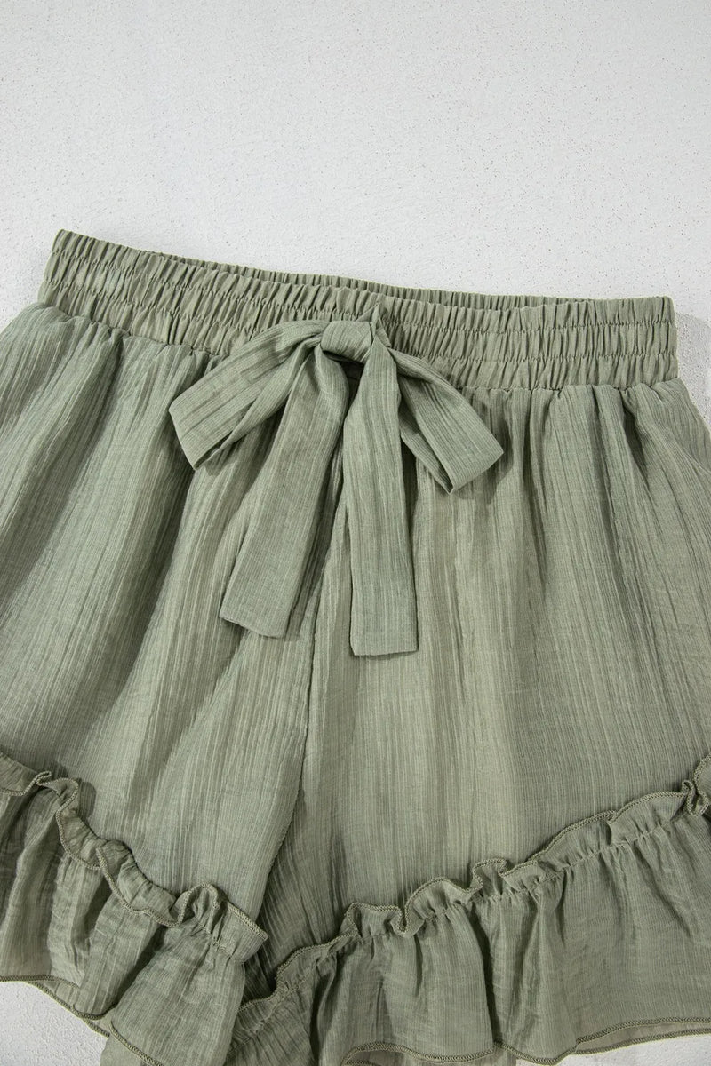 Green shorts with a tie waist on a white background