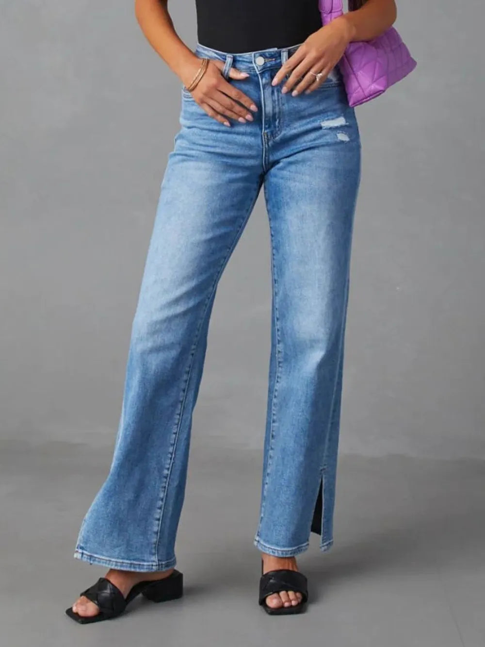 Person wearing blue jeans with a gray background