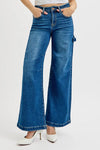 Blue wide-leg jeans worn by a person on a white background