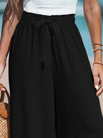 Person wearing a black skirt with a white top against a blurred background