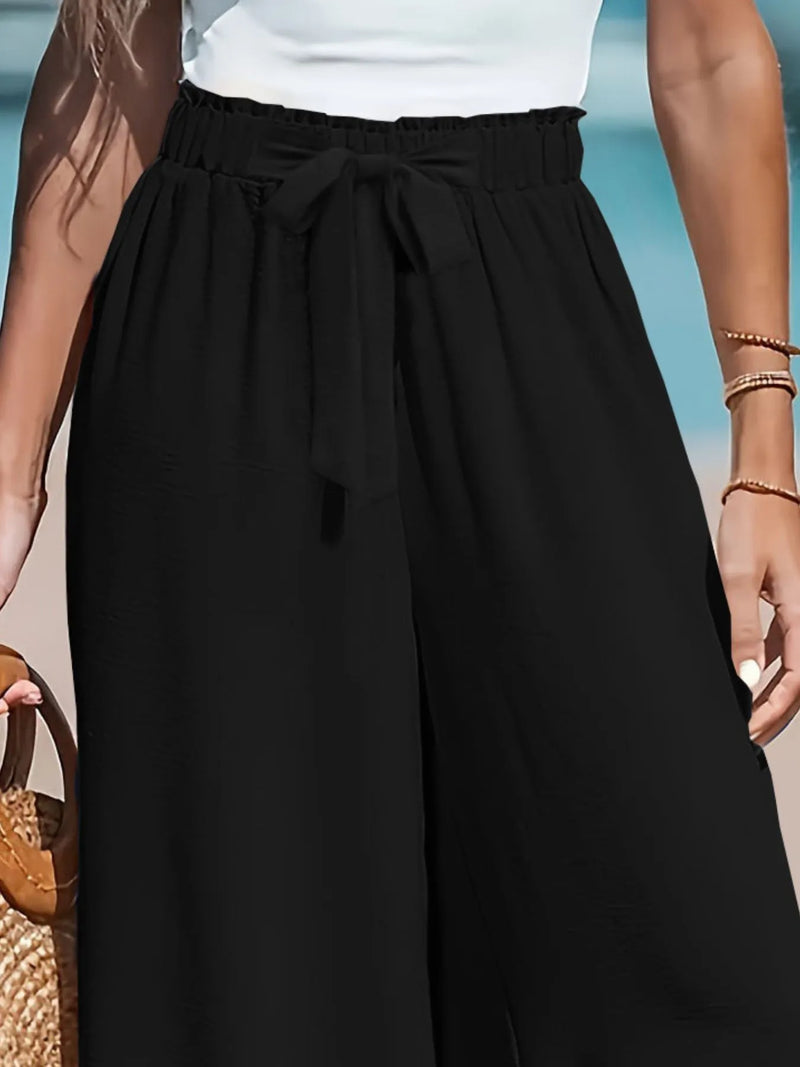 Person wearing a black skirt with a white top against a blurred background