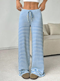 Person wearing blue and white striped pants in a living room setting.
