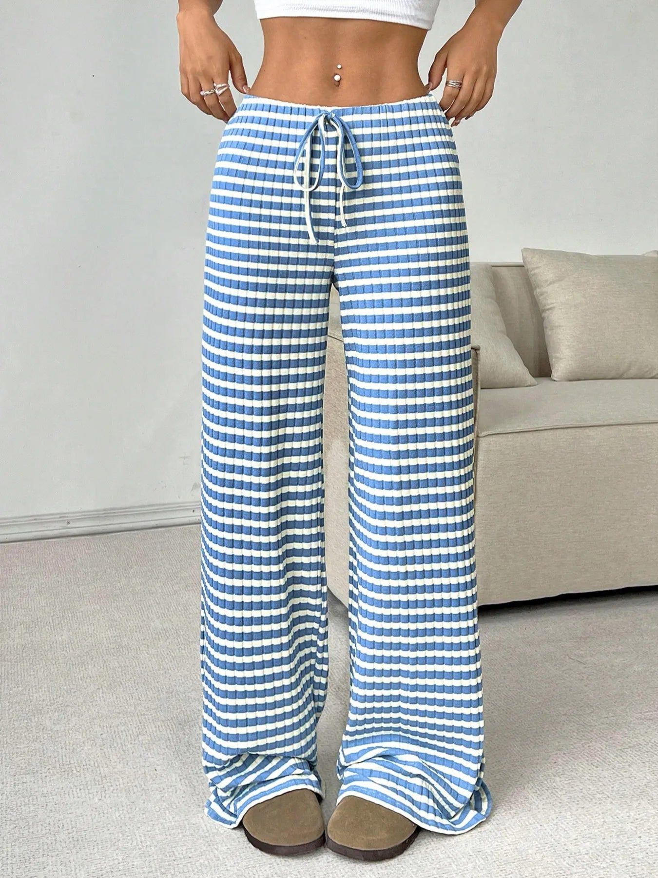 Person wearing blue and white striped pants in a living room setting.