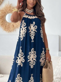 Woman wearing a blue dress with white patterns, holding a straw bag indoors.