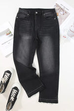 Black jeans on a white surface with sneakers and a newspaper.