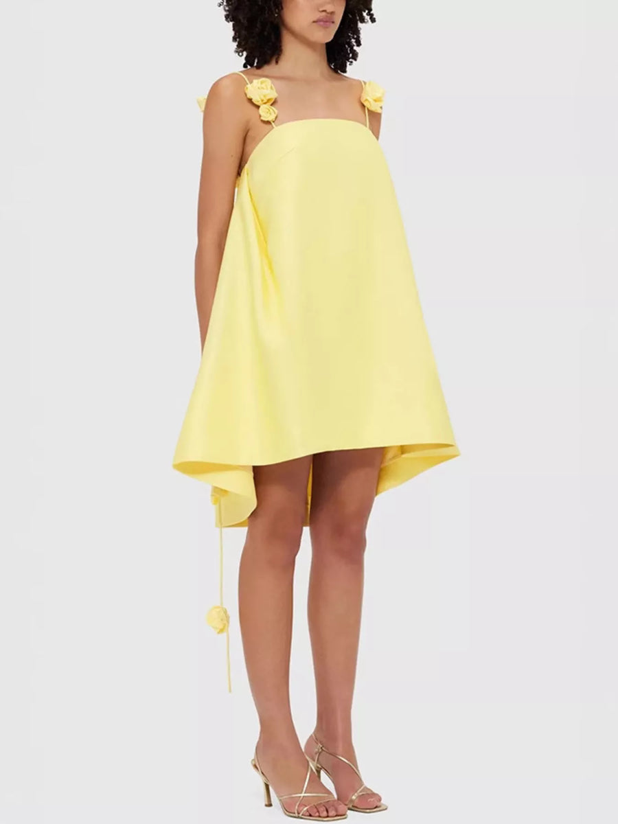 Yellow dress with floral straps worn by a model on a white background
