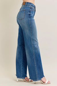 Blue jeans worn by a person on a plain background