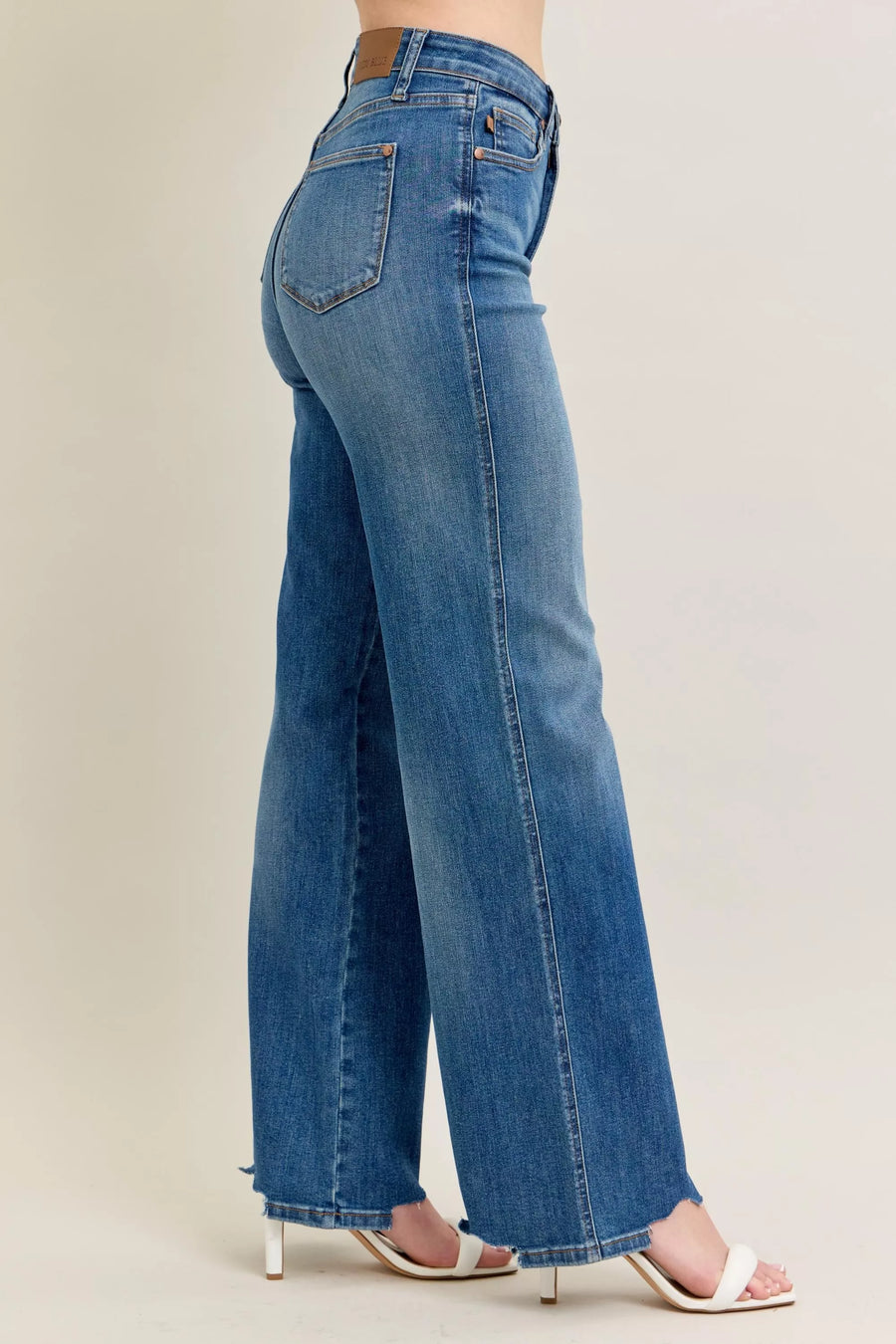 Blue jeans worn by a person on a plain background