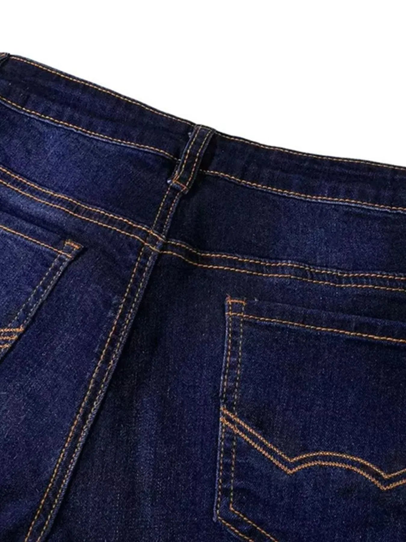 Close-up of blue denim jeans with stitching details on a white background
