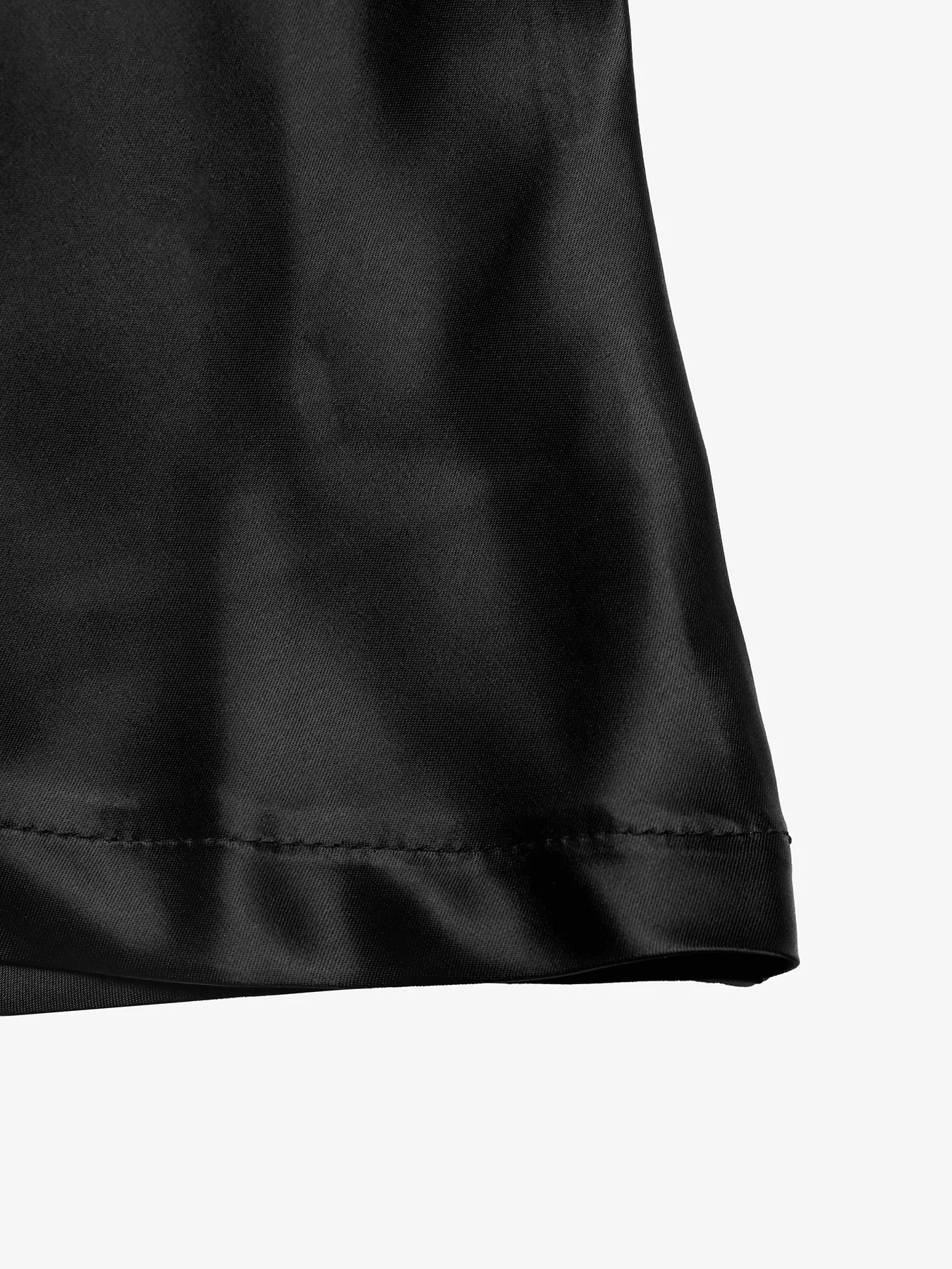 Close-up of a black satin fabric corner on a white background