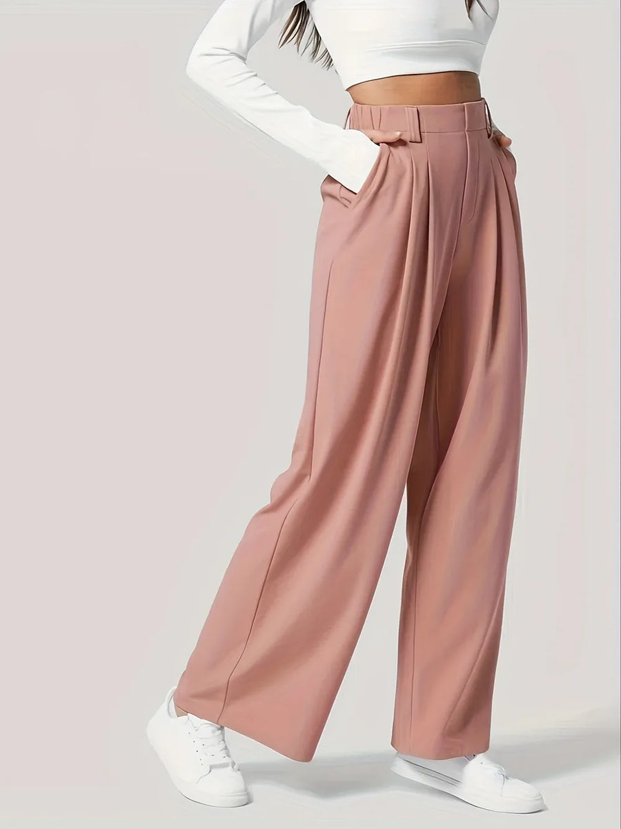 Pink wide-leg pants worn with a white long-sleeve top and white sneakers on a light gray background