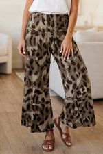 Person wearing leopard print pants in a casual setting