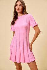 Woman wearing a pink dress against a beige background