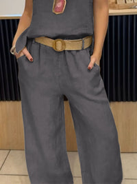 Person wearing a gray outfit with a belt in an indoor setting