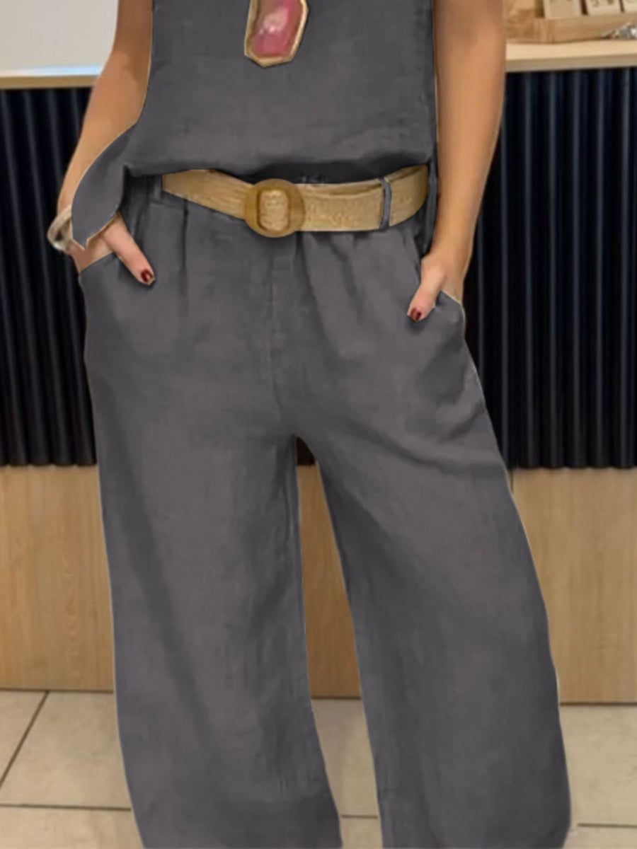 Person wearing a gray outfit with a belt in an indoor setting
