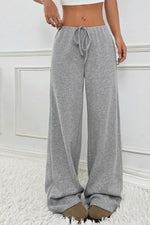 Gray sweatpants worn by a person on a white background
