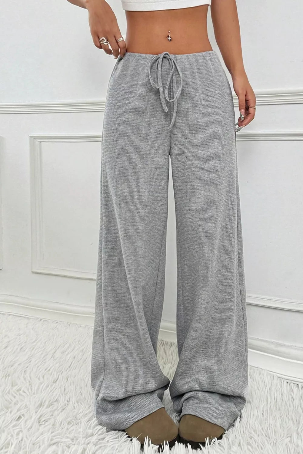 Gray sweatpants worn by a person on a white background